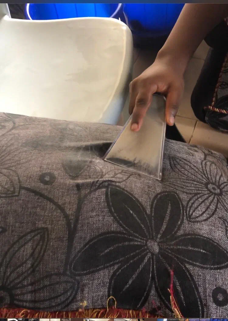 A team member deep-cleaning a patterned cushion with an extraction tool